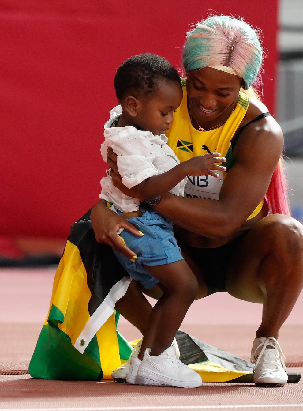 Shelly-Ann Fraser-Pryce celebrates her 100m title with two-year-old son Zyon (PA Images)