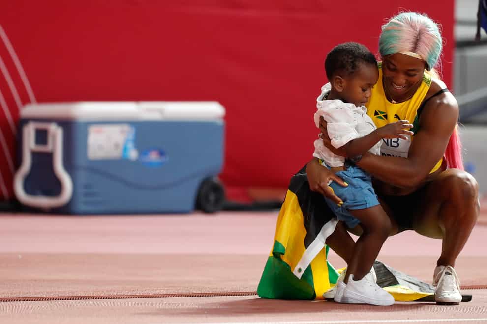 Shelly-Ann Fraser-Pryce celebrates her 100m title with two-year-old son Zyon (PA Images)