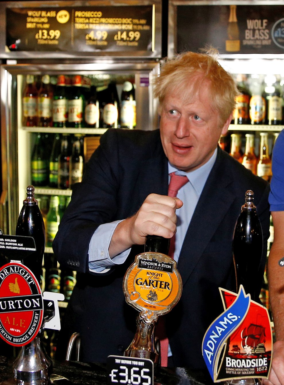 Tim Martin pulls a pint alongside Boris Johnson at a London Wetherspoon  pub last year. Now Martin has closed his pubs following the PM's direction (PA Images)