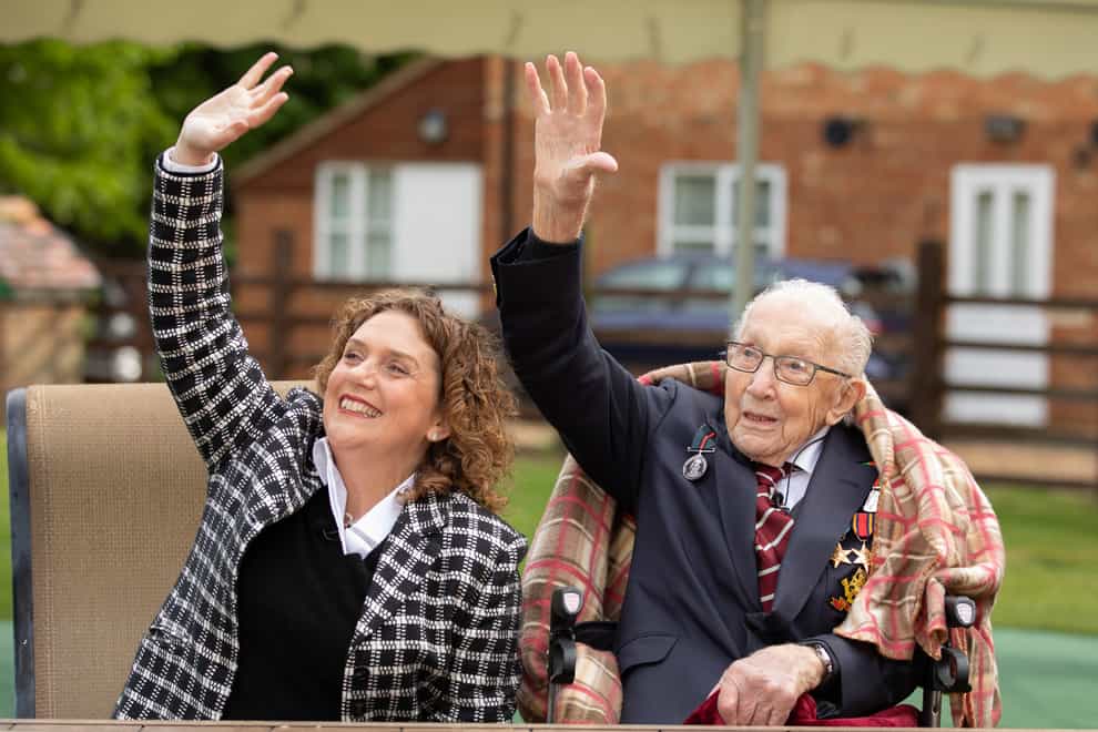 'Colonel' Tom and his daughter Hannah wave to the Battle of Britain flypast to mark his 100th birthday (PA Image)