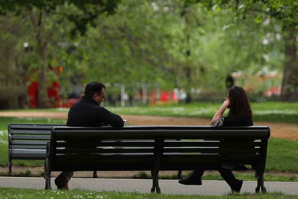 People observing social distancing on a bench in Hyde Park