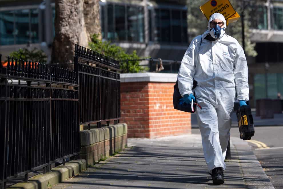A man wearing a protective face mask and clothing in Westminster, London