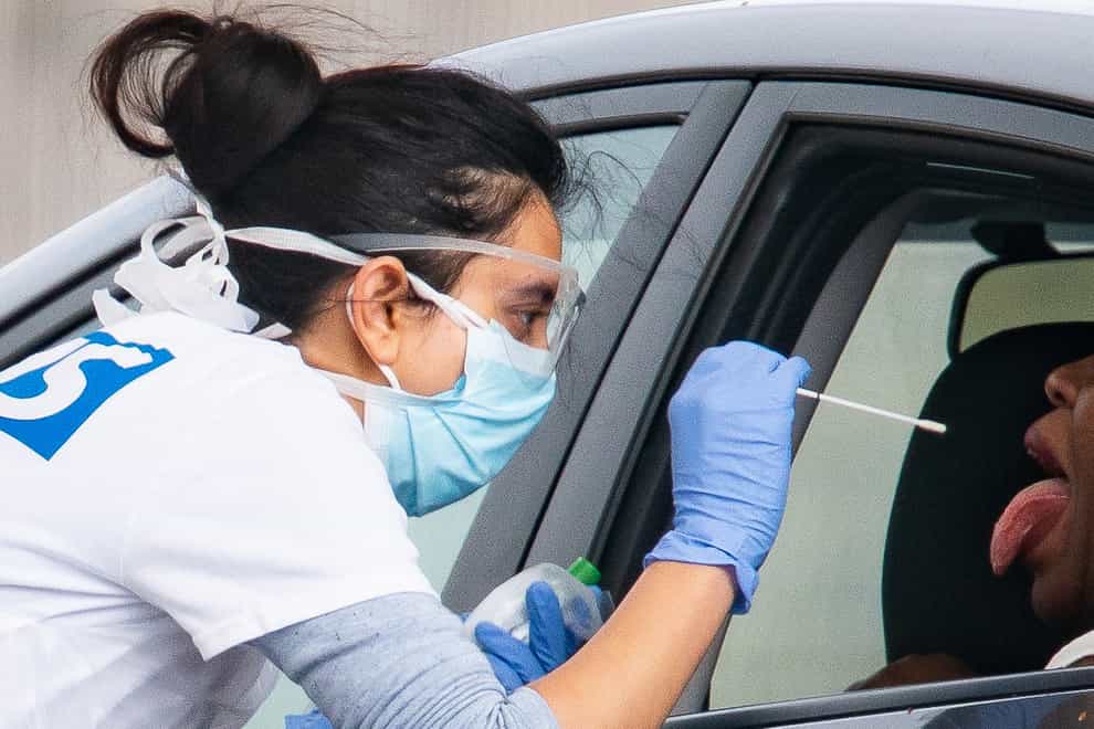 A medical worker takes a swab at a drive-in testing centre