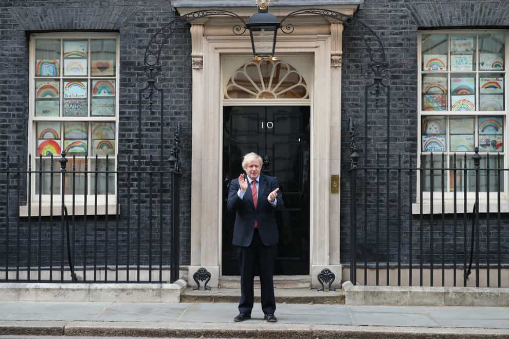 Prime Minister Boris Johnson stands outside 10 Downing Street in London as he joins in the applause to salute local heroes during Thursday’s nationwide Clap for Carers