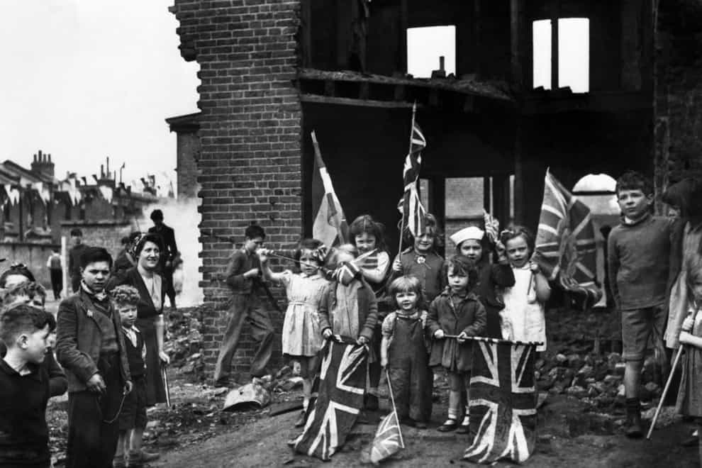 Young residents celebrate VE Day amid the ruins of their home in Battersea