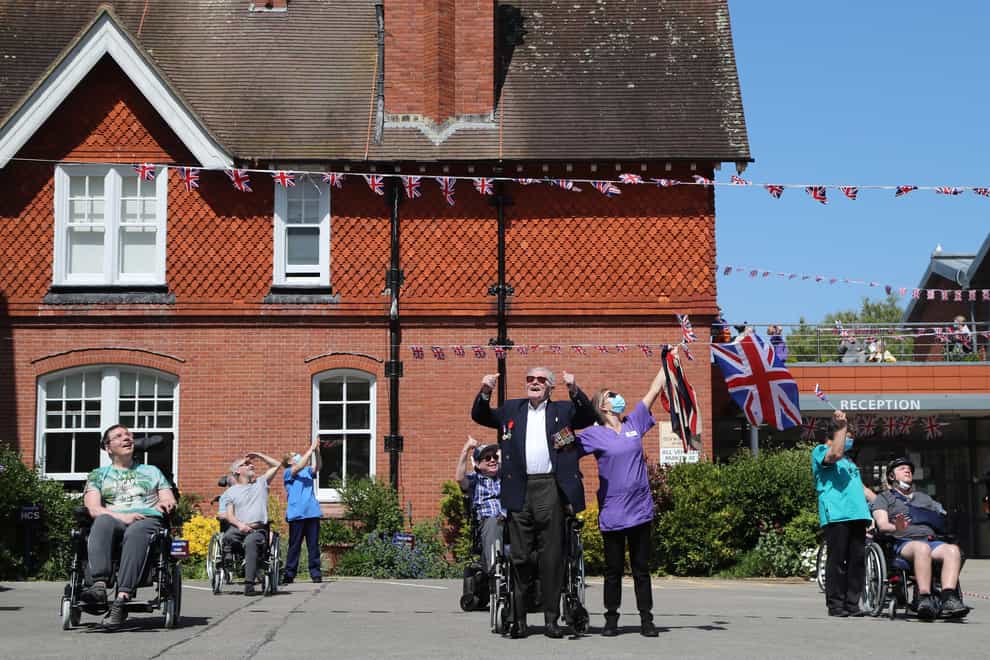 Second World War veteran Len Gibbon, 96, stands to watch a Spitfire fly over the Care for Veterans site in Worthing to mark the 75th anniversary of VE Day