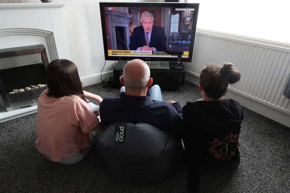 People in a house in Liverpool watch Prime Minister Boris Johnson addressing the nation about coronavirus (PA)
