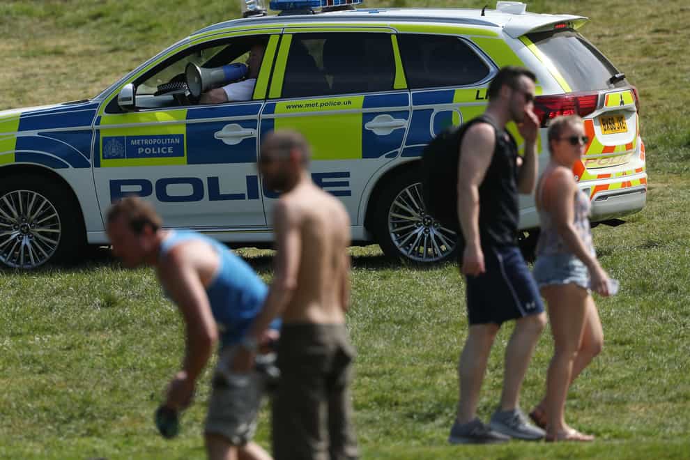 Police officers move sunbathers on