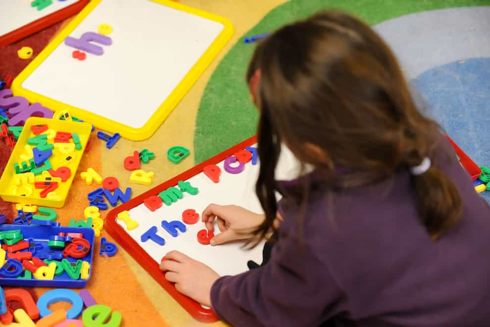 A child playing with plastic letters on a board