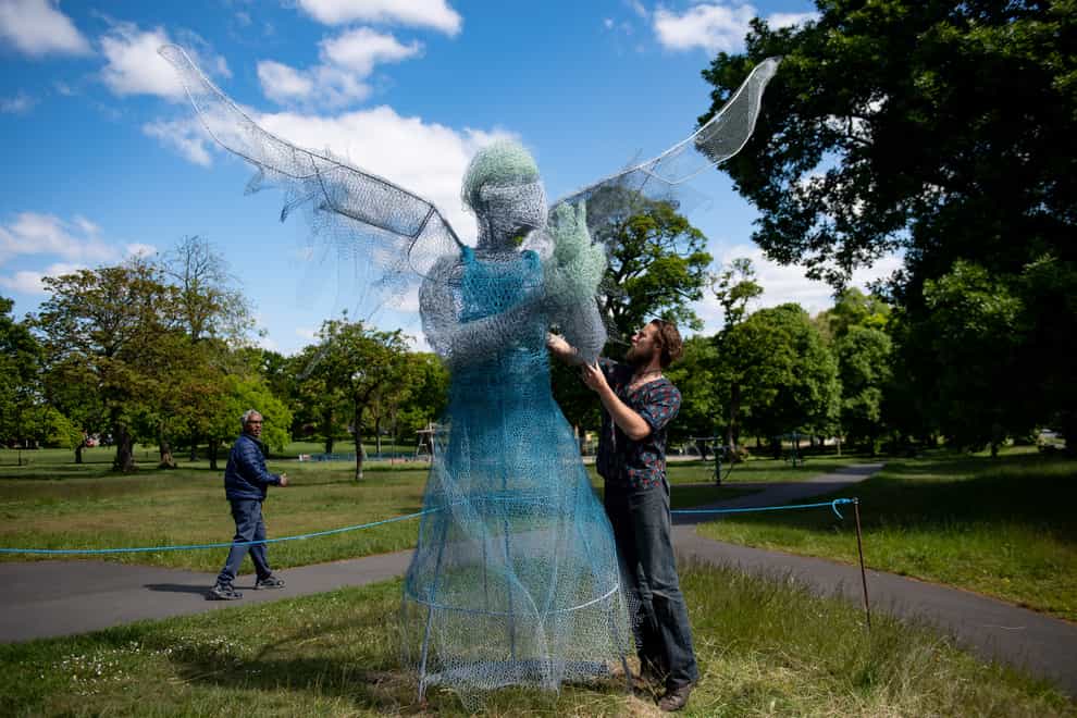 Sculptor Luke Perry beside his winged medical worker