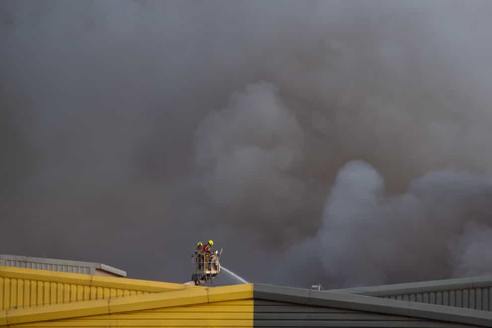 Fire fighters attend the scene of a fire on an industrial estate at Alfred’s Way in Barking, east London