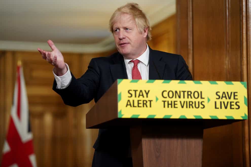 Prime Minister Boris Johnson in front of a podium bearing the Stay Alert message