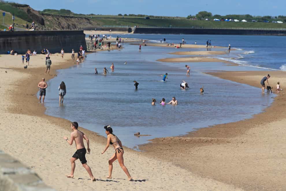 People enjoy the hot weather at Whitley Bay beach in Tyneside (PA)