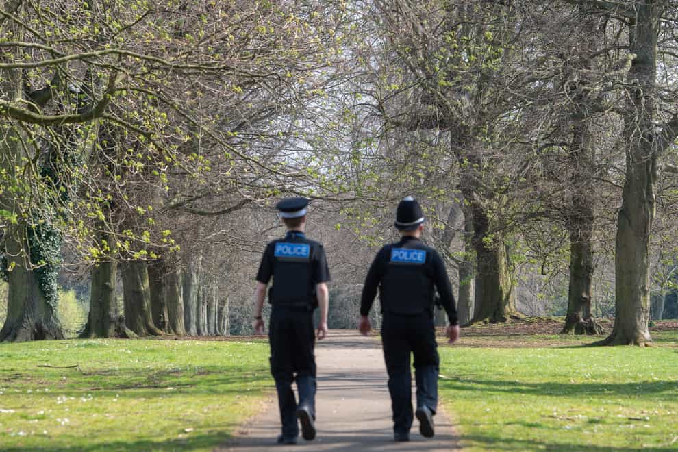 Police officers patrol a park