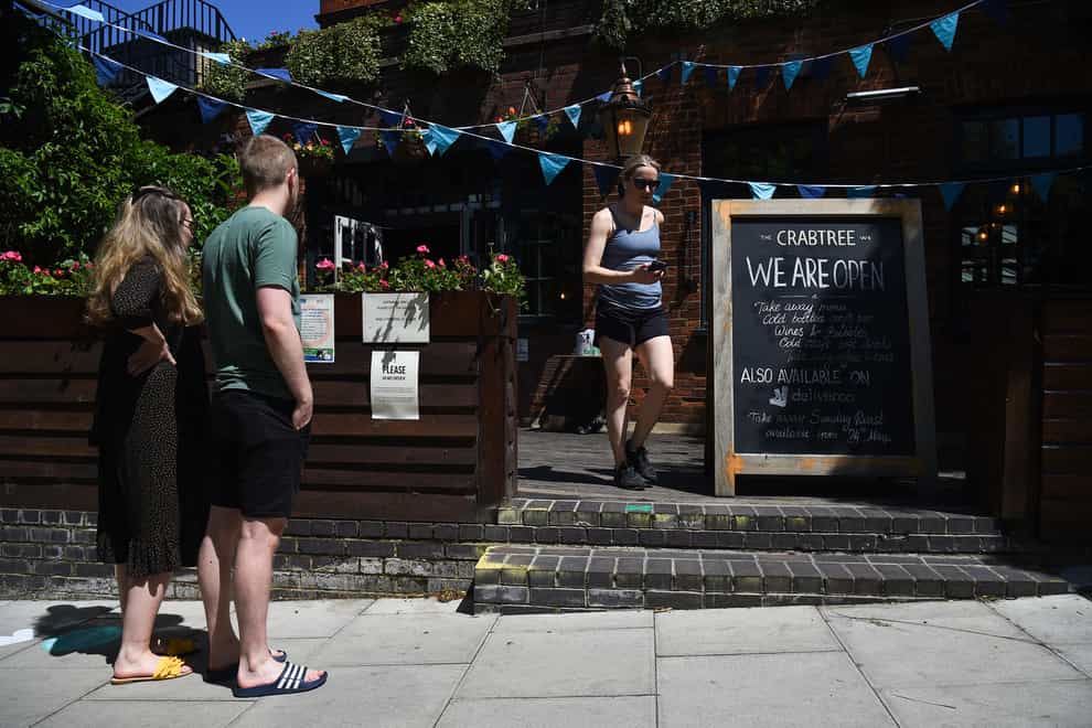 Customers queue outside The Crabtree pub in Fulham, London, which offers take away roast dinners (Kirsty O'Connor/PA)