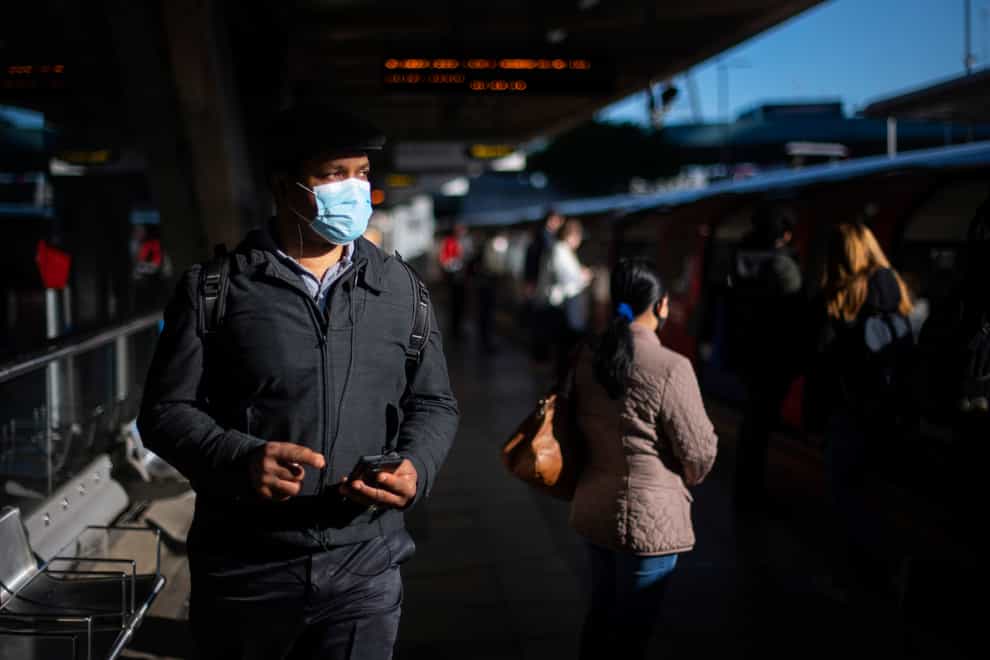 Passengers wear face masks on a Tube platform
