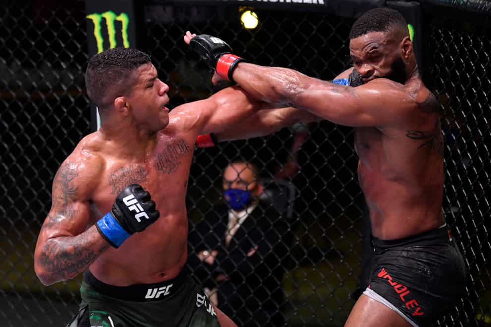 Gilbert Burns of Brazil (blue gloves) punches Tyron Woodley in their welterweight fight during UFC Fight Night