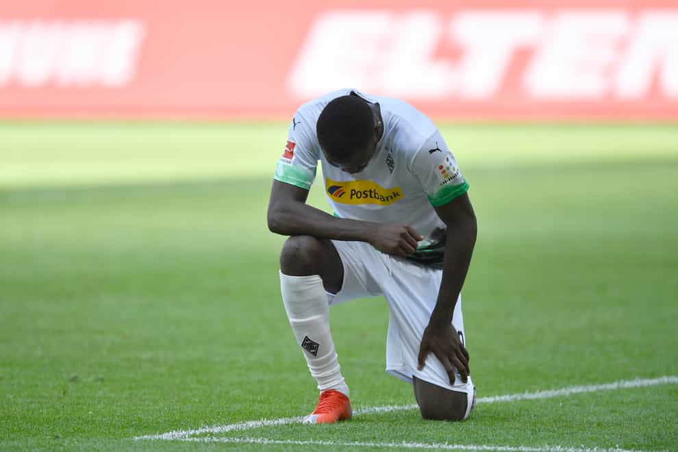Borussia Moenchengladbach’s Marcus Thuram takes a knee after scoring the first of two goals against Union Berlin in the Bundesliga..