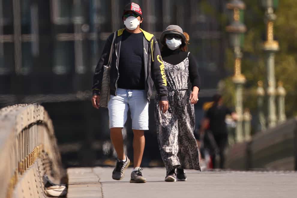 A couple wearing face masks on Westminster Bridge, London