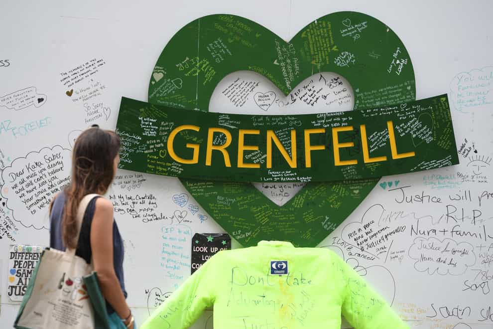 People at the Grenfell Memorial Community Mosaic at the base of the tower block in London on the third anniversary of the fire