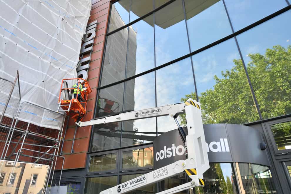 Workers remove the lettering from Colston Hall