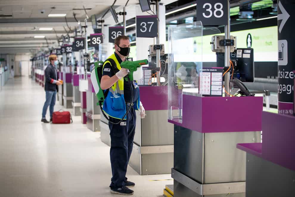Screens at the Edinburgh Airport check-in desks are disinfected