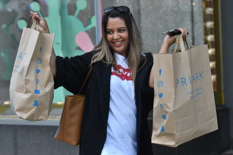 A customer carrying bags of shopping leaves Primark in Birmingham (Jacob King/PA)