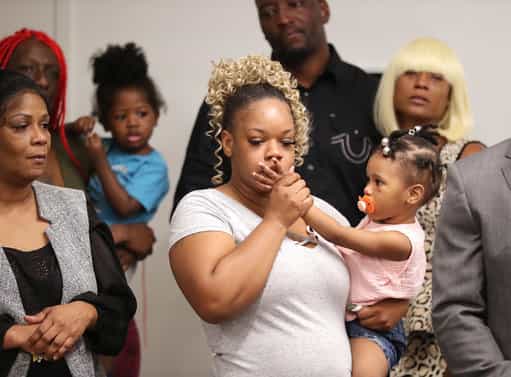Tomika Miller, the wife of Rayshard Brooks, holds their daughter Memory, 2, at today's press conference
