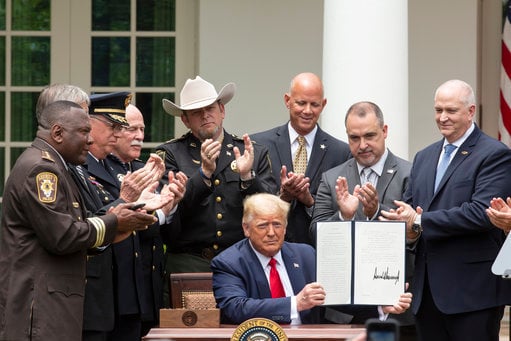  President Donald Trump displays an Executive Order on Safe Policing for Safe Communities after signing it in the Rose Garden of the White House 