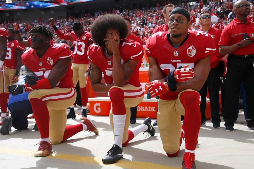 Colin Kaepernick (centre) famously knelt during the national anthem in 2016 to protest against police brutality 