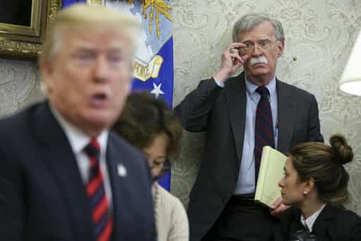 President Donald Trump speaks as former National Security Adviser John Bolton listens during a meeting in the Oval Office of the White House in 2018