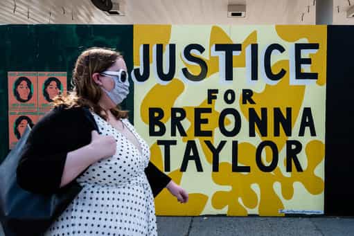 A woman walks past a mural by Theresa Rivera, which calls for justice for Breonna Taylor, in Brooklyn, New York
