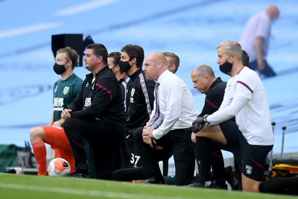 Burnley manager Sean Dyche and his staff take the knee