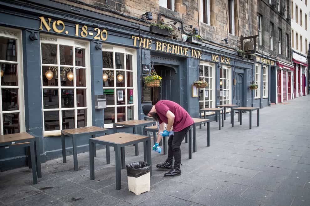 A worker cleans tables outside the Beehive Inn in Edinburgh
