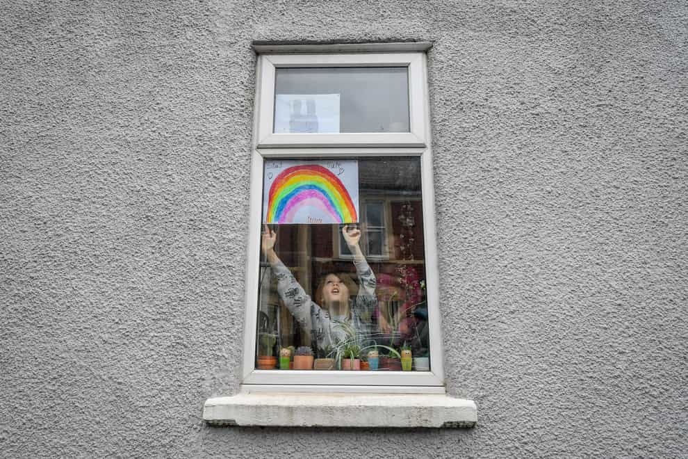 Jack Tucker, seven, placing his rainbow in the window of a house in Bedminster, Bristol