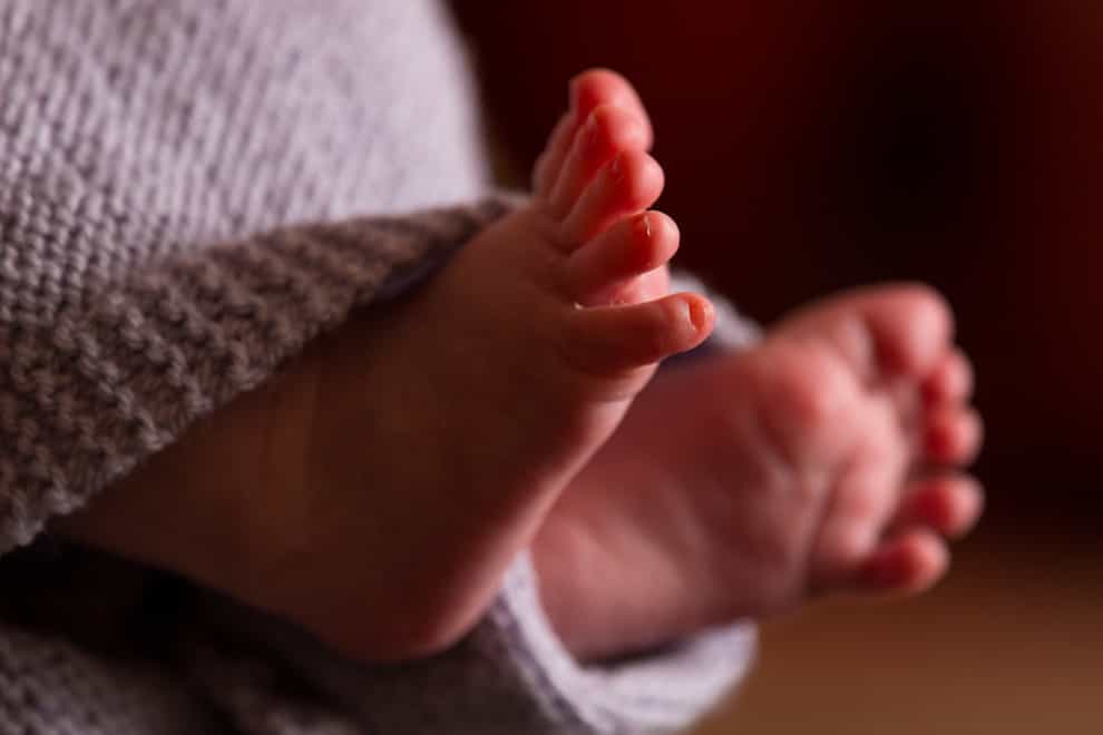 The feet of a baby wrapped in a blanket