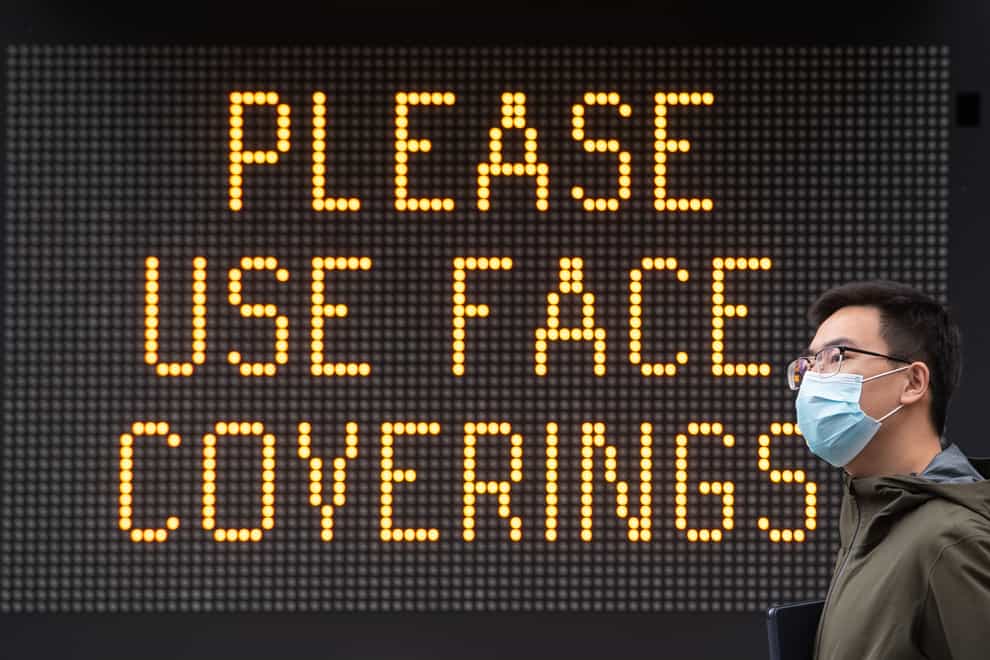 A 'Please use face coverings' notice