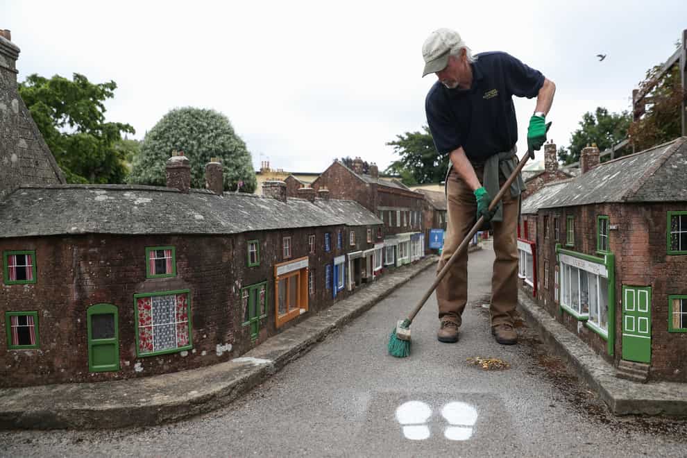 A volunteer sweeps the streets at the Wimborne Model Town and Gardens in Wimborne, Dorset, as they prepare to reopen to members of the public on Saturday following the easing of lockdown restrictions in England.