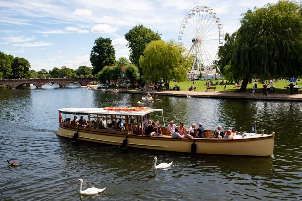 People enjoy a boat trip on a warm day in Stratford-upon-Avon, Warwickshire