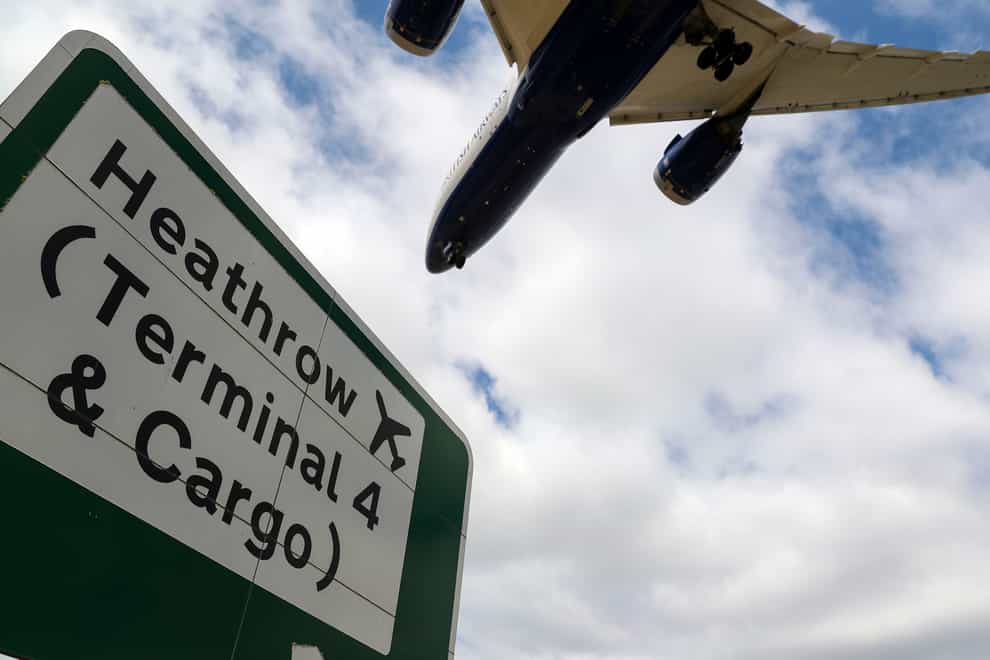 A plane flies over a Heathrow Terminal 4 sign