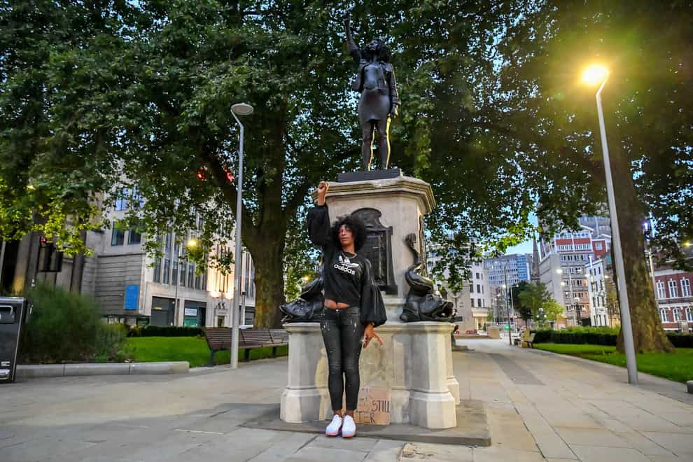Jen Reid poses in front of her black resin and steel statue titled A Surge of Power (Jen Reid) 2020, by Marc Quinn (Ben Birchall/PA)