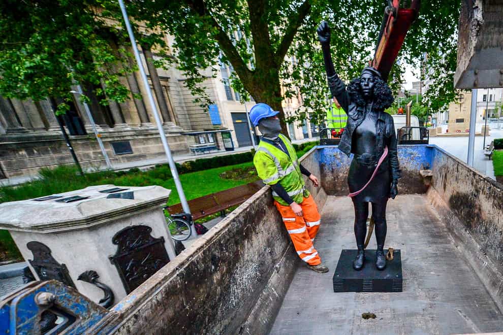 Contractors use ropes to move the sculpture onto a lorry 