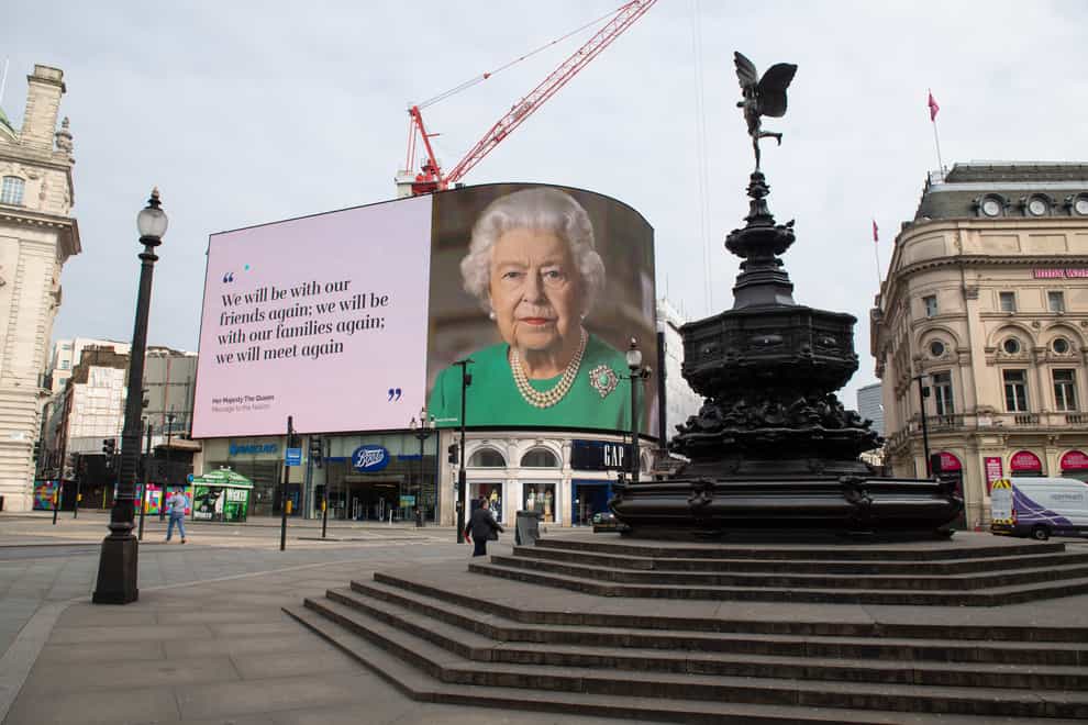 An image of the Queen with a quote from her televised address in London’s Piccadilly Circus