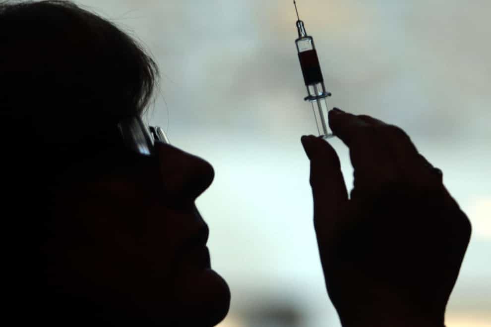 A nurse prepares to administer a vaccination