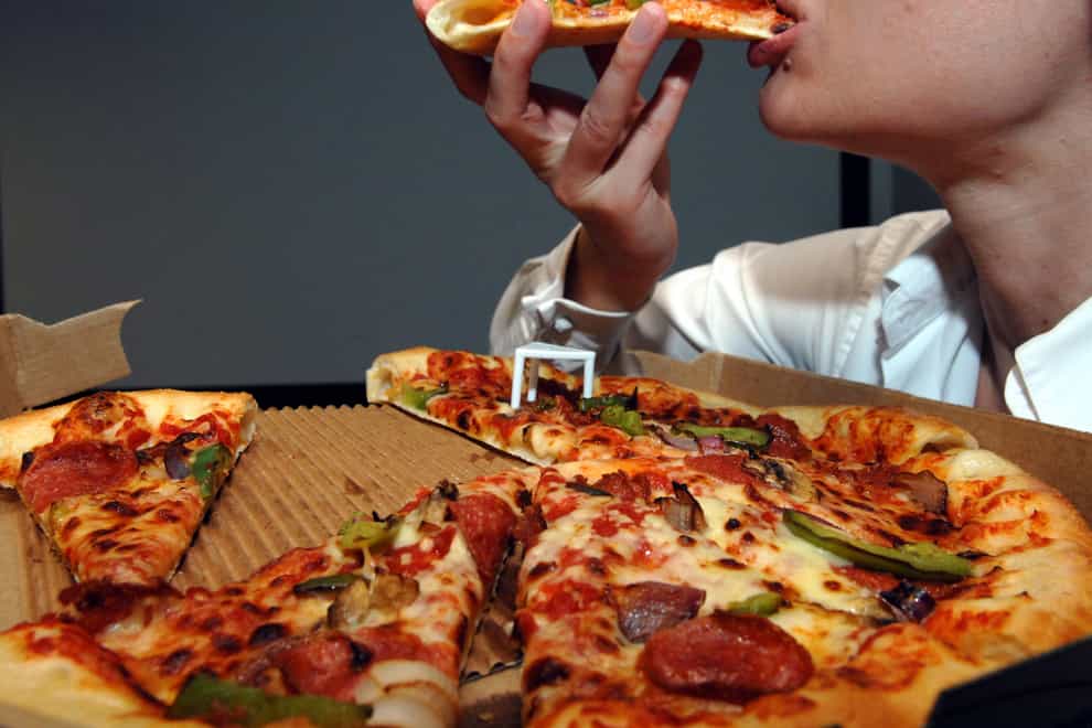 A person eating pizza (Steve Parsons/PA)