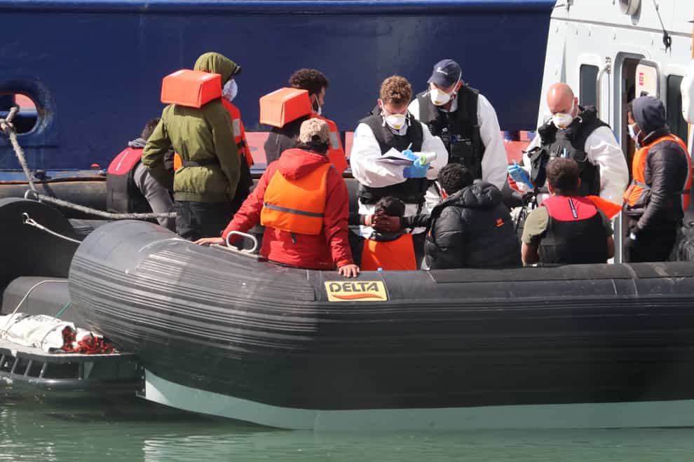 A group of people thought to be migrants are brought into Dover, Kent