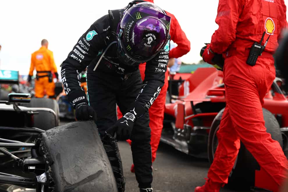 Lewis Hamilton inspects his deflated tyre after the race