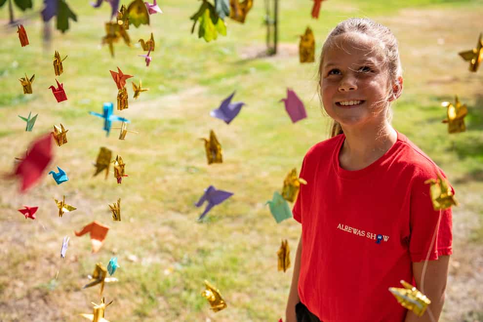 Emily Turner, nine, hangs origami peace cranes in the Anglo-Japanese Grove of Reconciliation at the National Memorial Arboretum in Alrewas, Staffordshire, to mark the 75th anniversary of the atomic bomb being dropped on Hiroshima