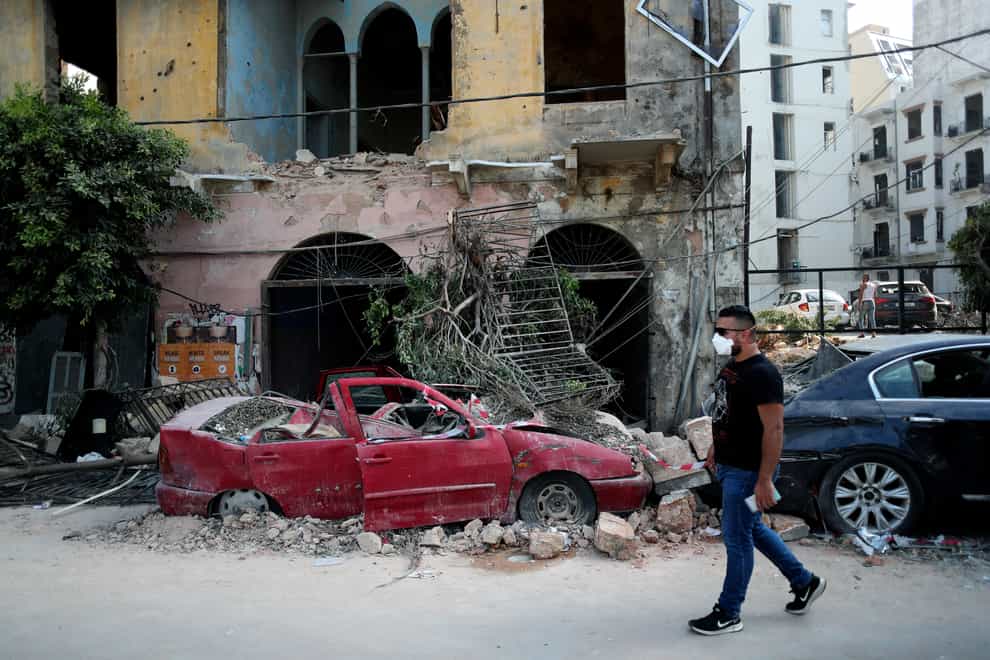 A man walks past a destroyed car in a neighbourhood near the scene of Tuesday’s explosion in Beirut, Lebanon