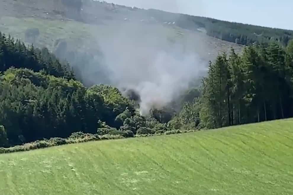 Smoke billows from the train on the track in the countryside near Stonehaven